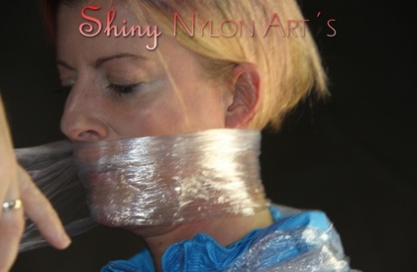 White girl is wrapped in plastic while sporting nylon clothing 22322700